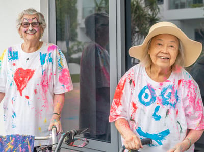 Two residents enjoying a colorful outdoor art activity