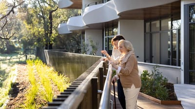 Residents enjoying a sunny balcony with a caregiver