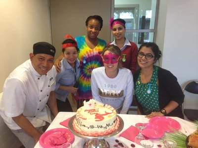 Staff and residents celebrating with a birthday cake