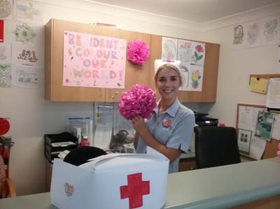 Nurse holding a craft flower in a colorful reception area