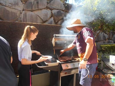 Staff grilling food at an outdoor barbecue event