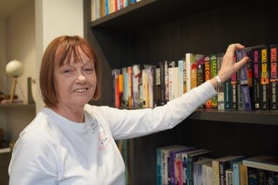 Staff member arranging books on a shelf