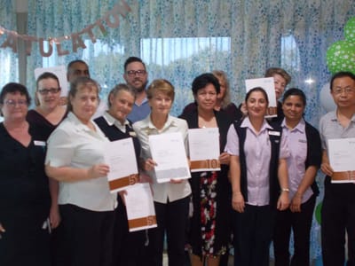 Staff members celebrating with certificates at an event