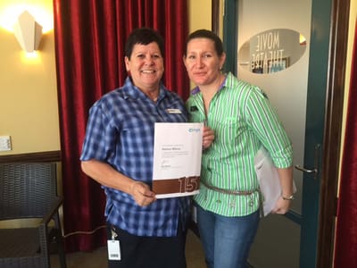 Staff members proudly displaying an award certificate