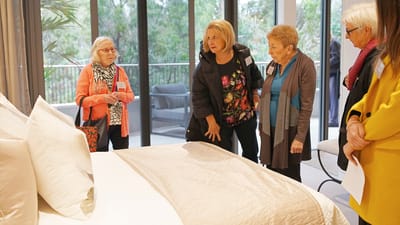 Residents examining a bedroom display during a tour