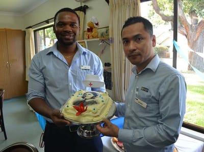 Staff presenting a cake during a celebration