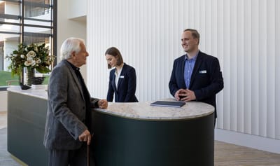 Staff assisting a resident at the reception desk