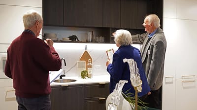 Residents and staff discussing in a modern kitchen area