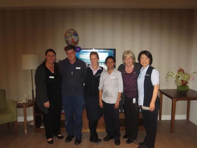 Staff members posing together in a common area