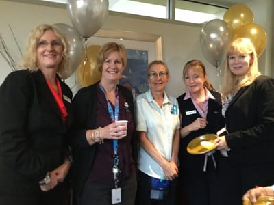 Staff members celebrating with balloons and drinks
