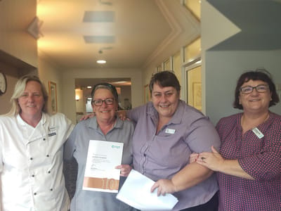 Staff celebrating with a resident in a common area