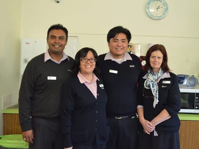 Staff members posing in a facility kitchen