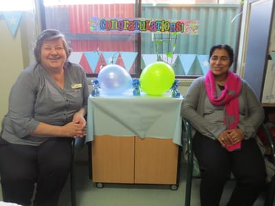 Two staff members celebrating with decorations and balloons