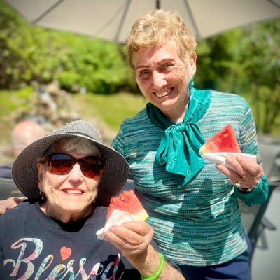 Residents enjoying watermelon outdoors on a sunny day
