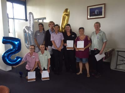 Staff celebrating a milestone with balloons and certificates