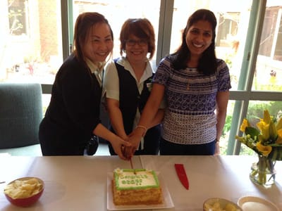 Staff celebrating with a cake at an event