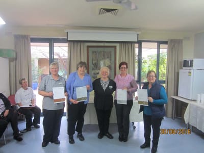 Residents and staff holding certificates in a common area