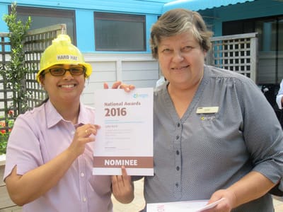 Staff members holding award nominations in an outdoor area