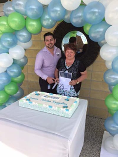 Celebration with a cake and balloons at a senior living facility