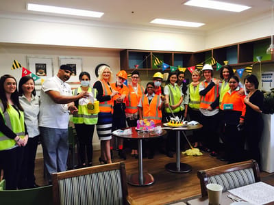 Staff and residents celebrating with yellow safety gear