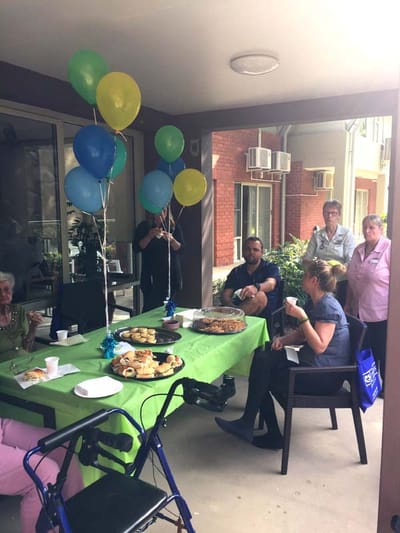 Residents enjoying a celebration with food and balloons