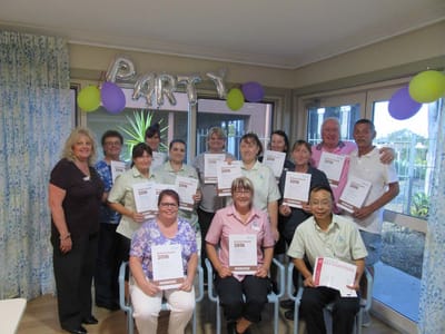 Staff and residents celebrating with awards in a common area