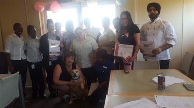 Staff members celebrating achievements with a dog