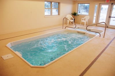 Indoor therapy pool area with water and seating