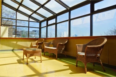 Bright common area with wicker chairs and large windows