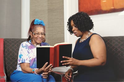 Residents reading together in a cozy lounge area