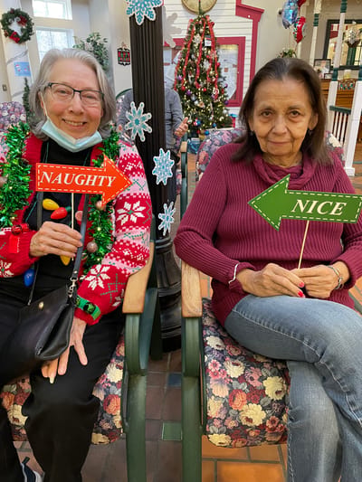 Two residents holding signs 'Naughty' and 'Nice'