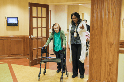 Staff assisting a resident in a hallway