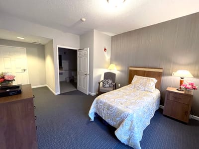 Cozy private resident room with a bed and bedside table