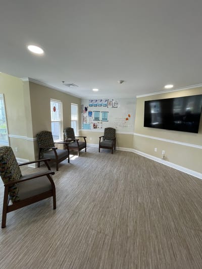 Bright interior common area with chairs and a TV