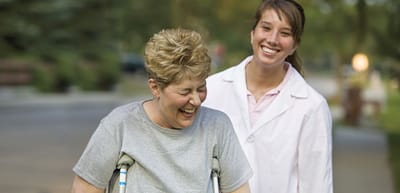 Resident and staff enjoying an outdoor walk