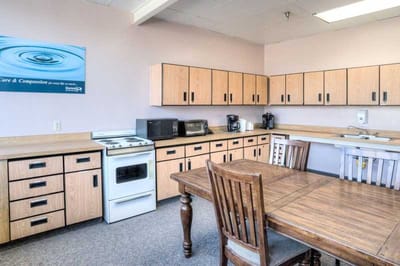 Kitchen area with cabinets and dining table.