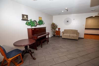 Cozy lounge area with piano and seating.