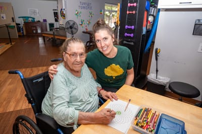 Senior resident enjoying an art activity with staff