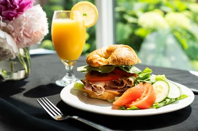 A plate featuring a sandwich and a drink.