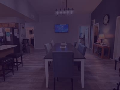 A dining area with long table and chairs