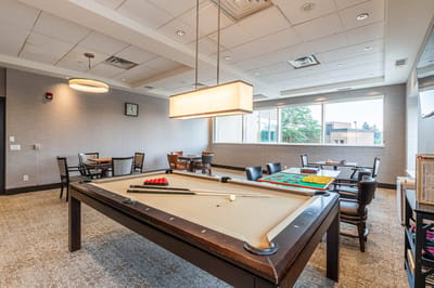 Interior game room with pool table and seating.