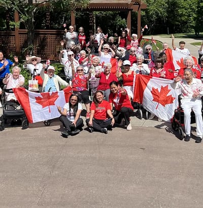 Residents celebrating with Canadian flags outdoors.