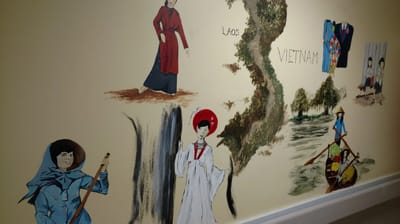 Mural depicting cultural scenes on an interior wall.