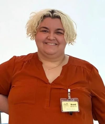 A staff member smiling with a name badge