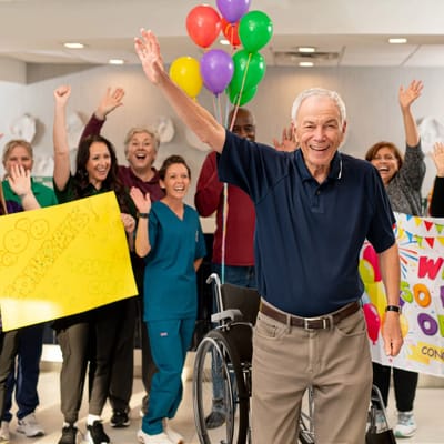 Happy residents and staff celebrating with balloons.