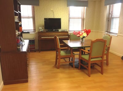 Cozy common area with table and flowers.