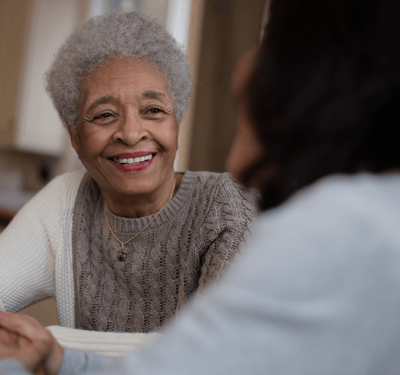Smiling senior woman interacting with another person.