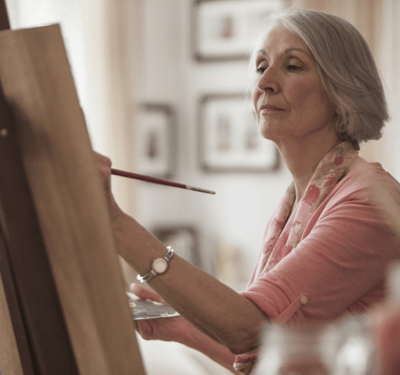 Senior woman painting in a bright room