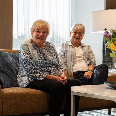 Two smiling residents in a common area