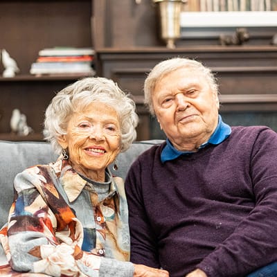 Elderly couple sitting together on a couch